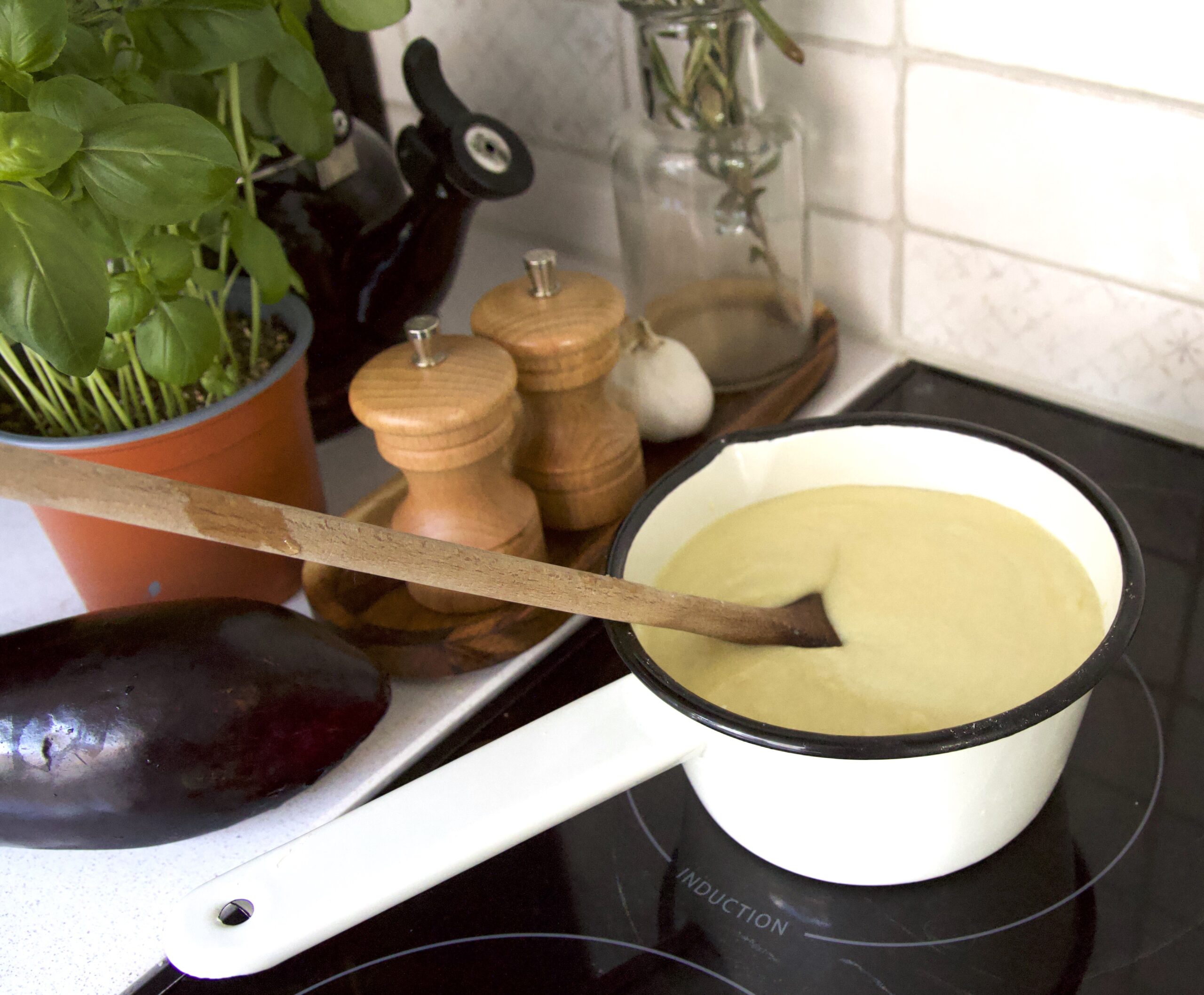 bechamelsaus in steelpan voor lasagne met aubergine